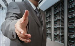businessmen offer hand shake in a technology data center
